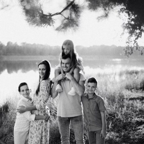 A joyful family enjoying time by the lake in a serene setting.