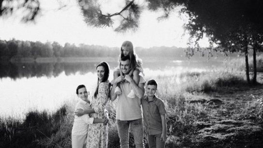 A joyful family enjoying time by the lake in a serene setting.